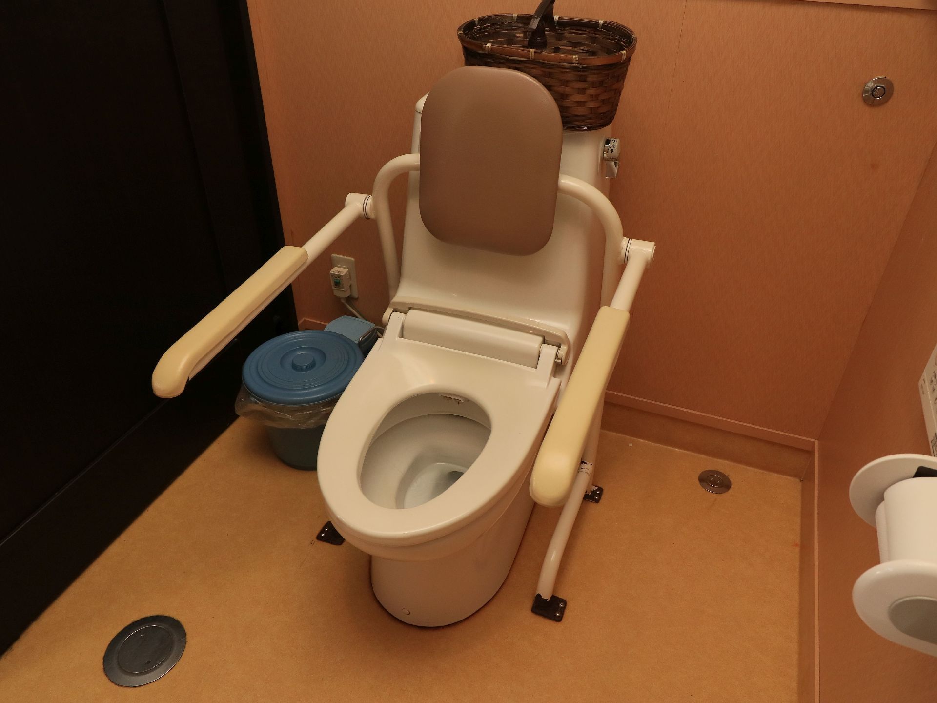 温水洗浄便座器が完備されたトイレには、背もたれパッド付きのレバー式手すりが設置されている。移動スペースが確保される。