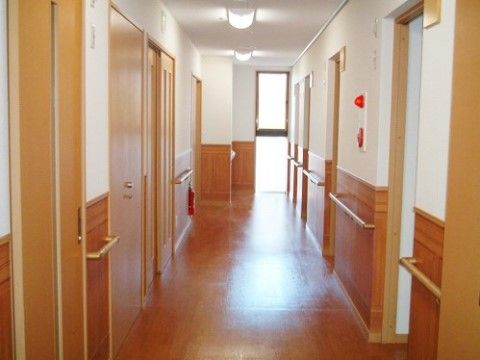 正面突き当りに窓があり、向かって右手には扉がない入口が、左には扉付きの入口と通路が並んでいる。扉や入口の間の壁に手すりがある。