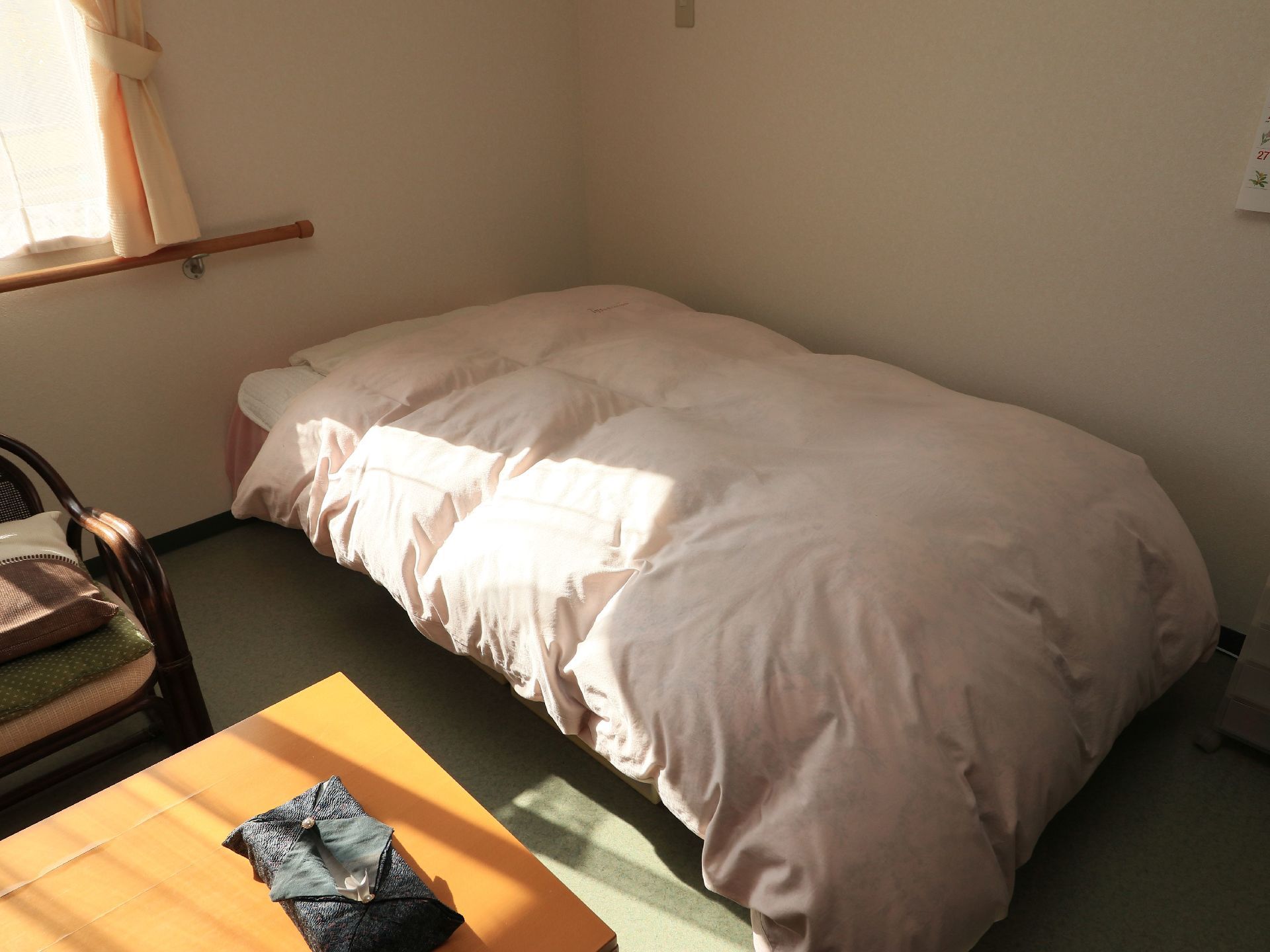 居室に木製のベッドを置いている。ふんわりとした掛け布団を用いて、快適な眠りにつくことができる環境である。