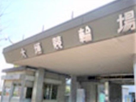 競輪場の入り口周辺の外観である。入り口には大きな屋根が設けられており、屋根には施設名が表示されている。