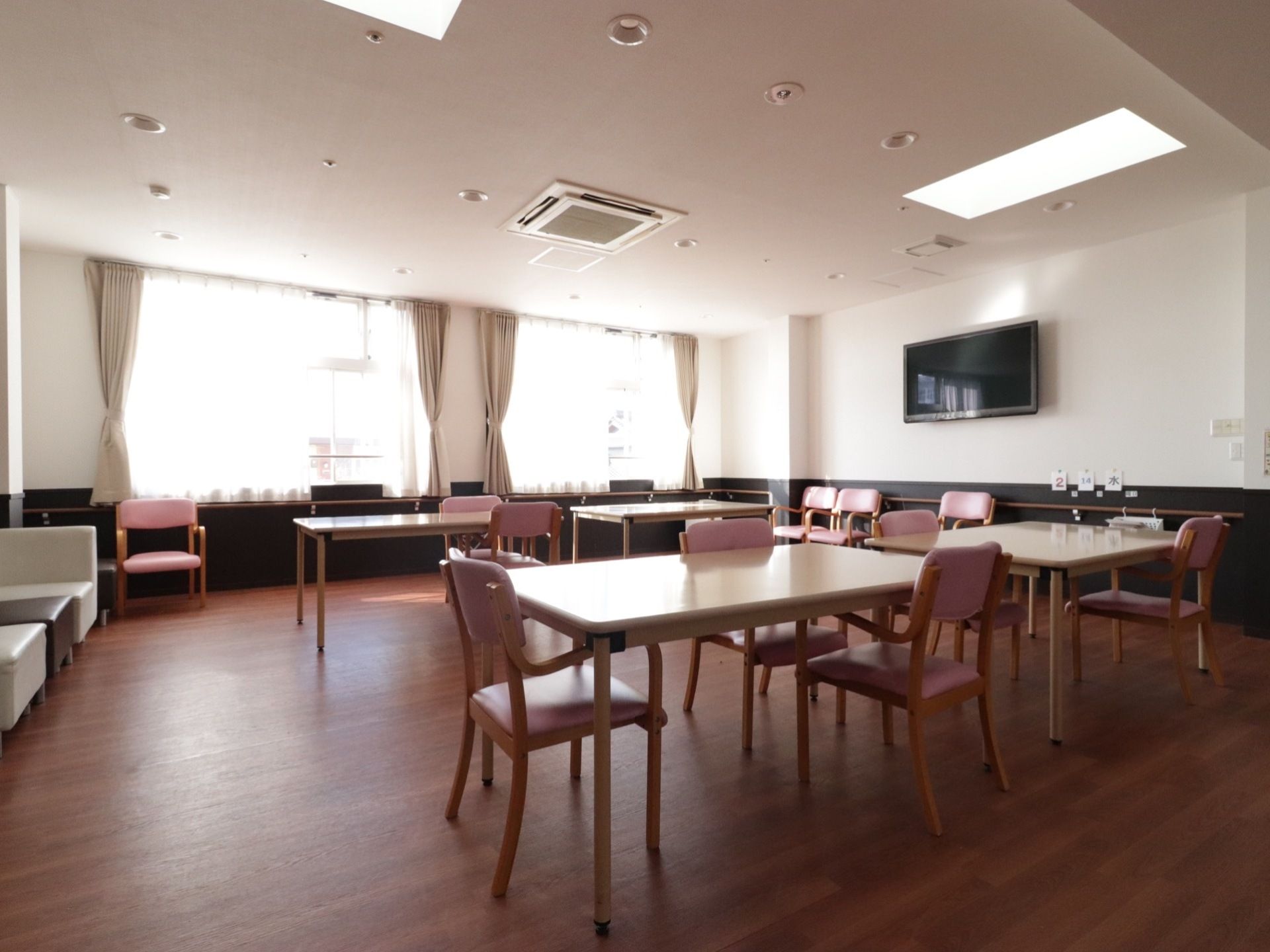 清潔感のある食堂は明るく、机と机の間隔があり広々としている。壁や椅子に手すりが付いており、転倒防止につながっている。