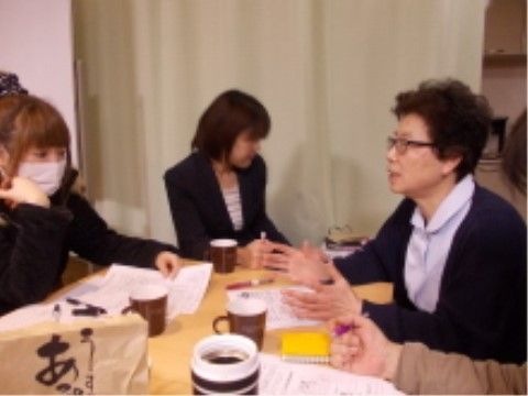お茶をしながら話し合いをする介護施設のスタッフの様子。