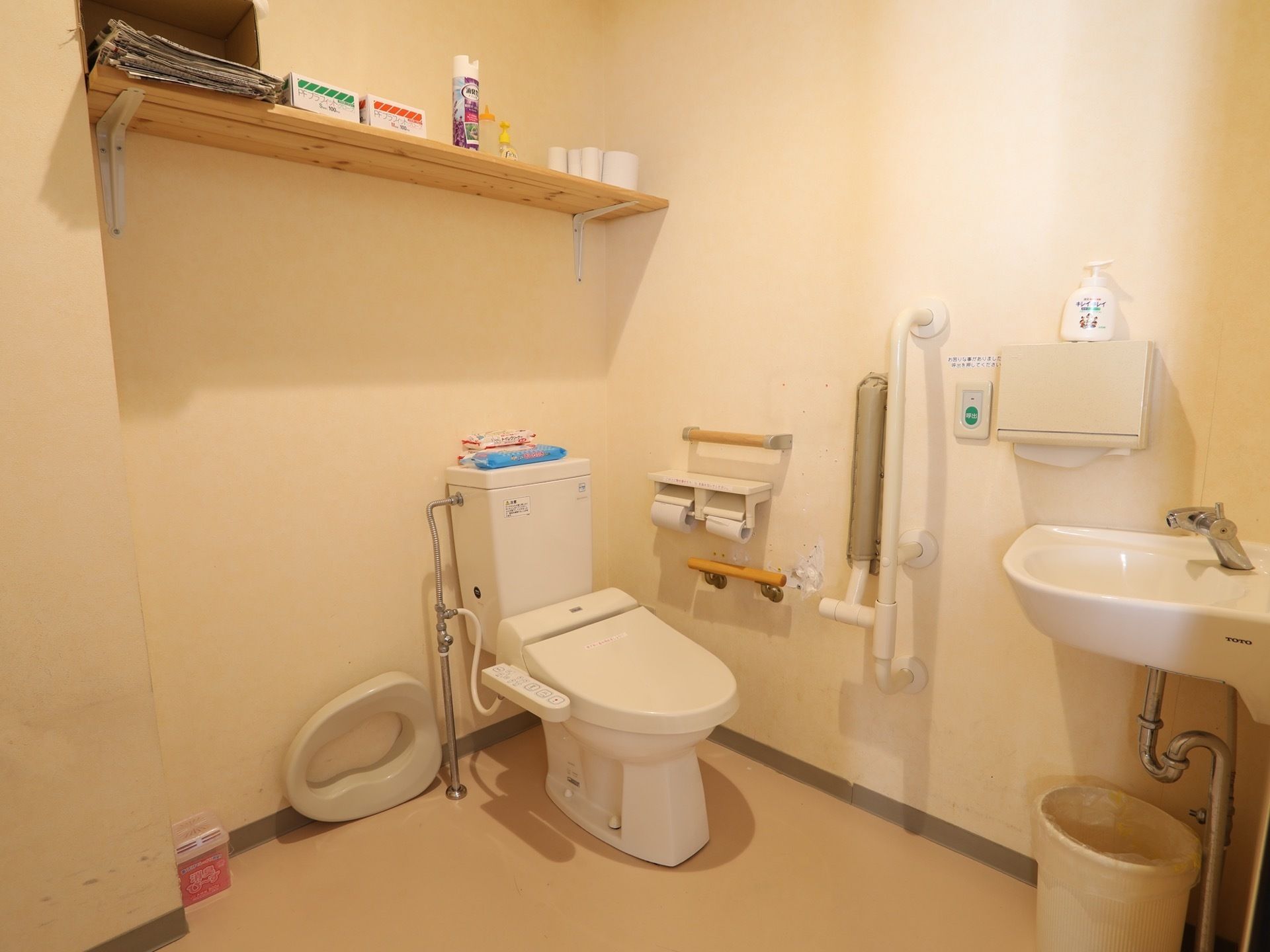スペースに余裕のある個室内に、洋式トイレと洗面台が備わっている。壁には手すりやナースコールが設置されている。