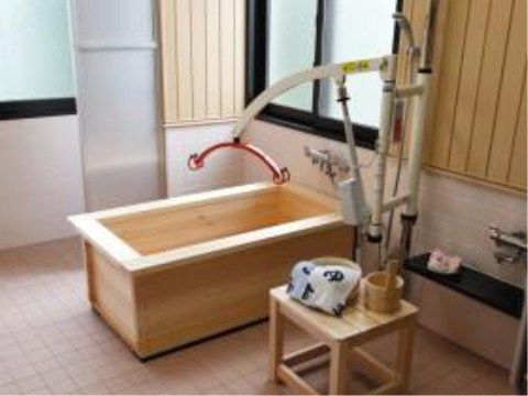 床面はタイル張りになっており、介護度の高い方にも入浴していただけるよう、木製の浴槽と、介助機器が設置されている。