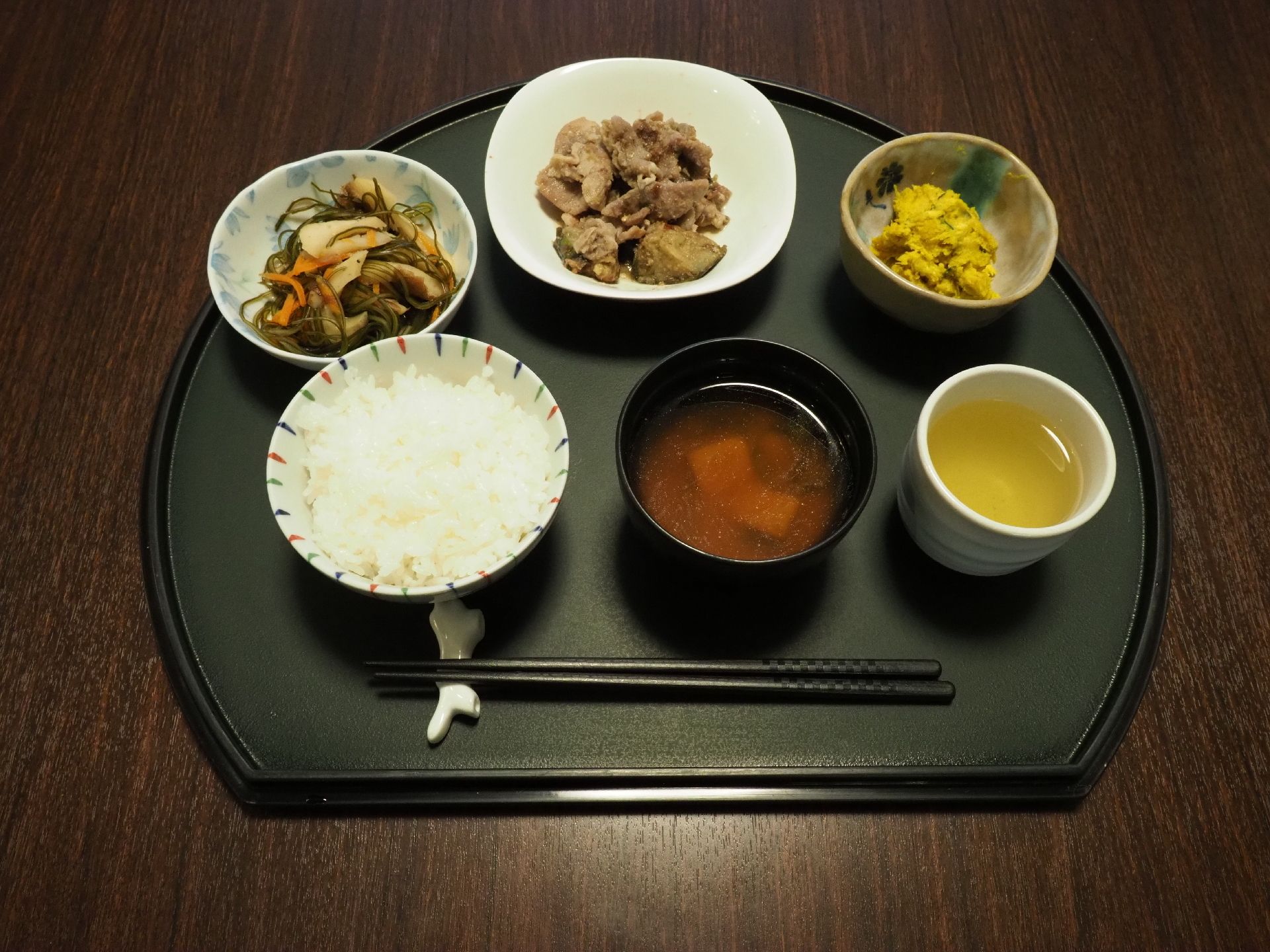 ある日の食事メニューである。ご飯とみそ汁に加えおかずが三品用意されている。そしてお茶もある。彩りが良い。