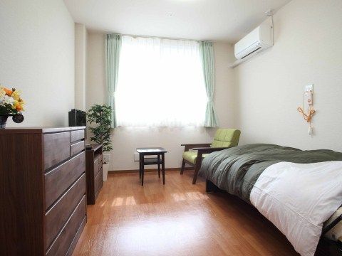 居室はベッド、インテリア家具などを配置しても、ゆったりと生活スペースを確保できる。壁には緊急時のナースコールを備えている。