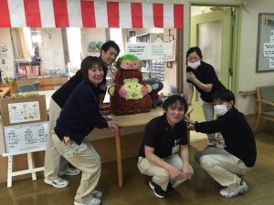 笑顔のスタッフと手作り人形